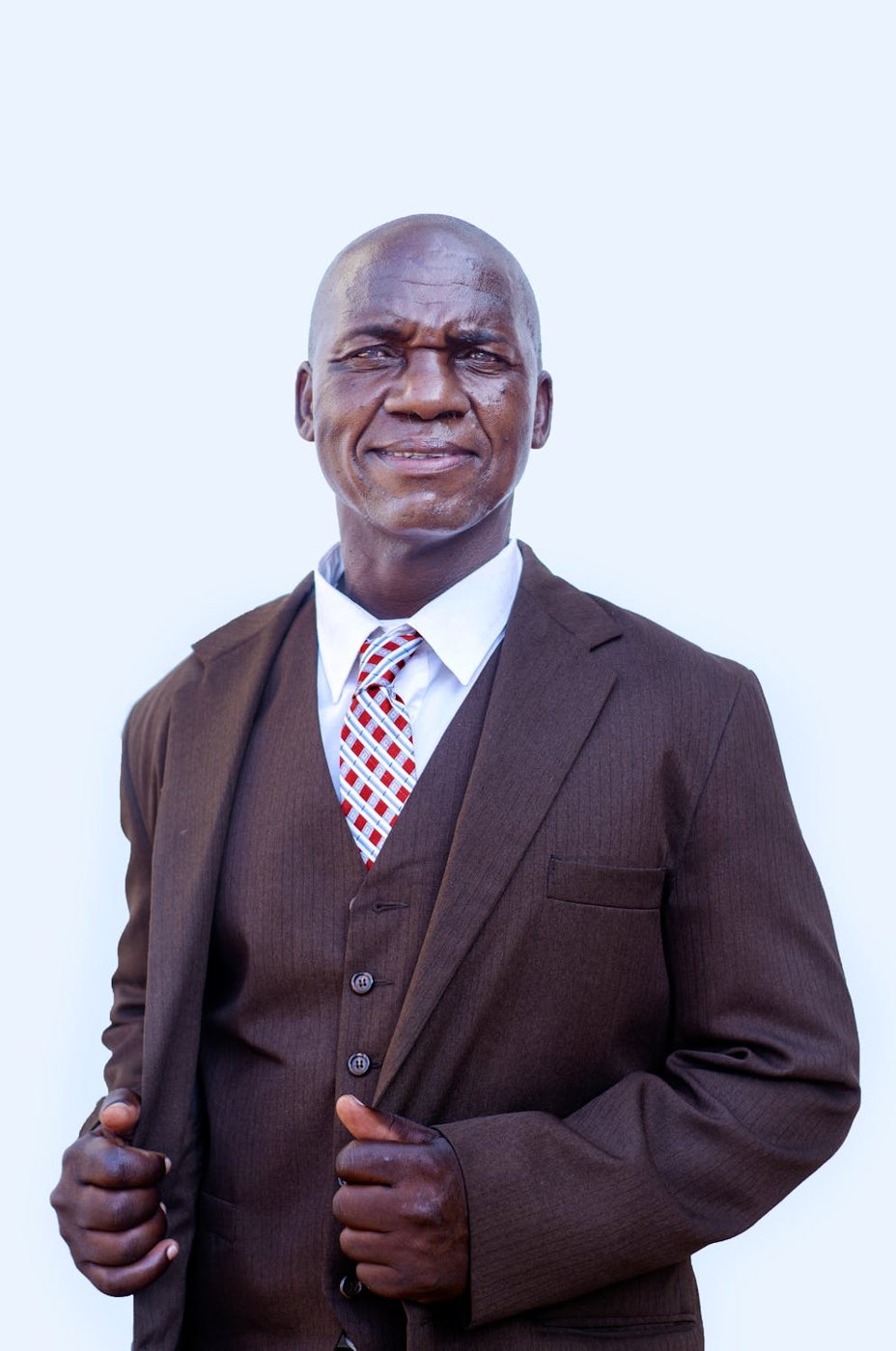 An older man in a suit, smiling