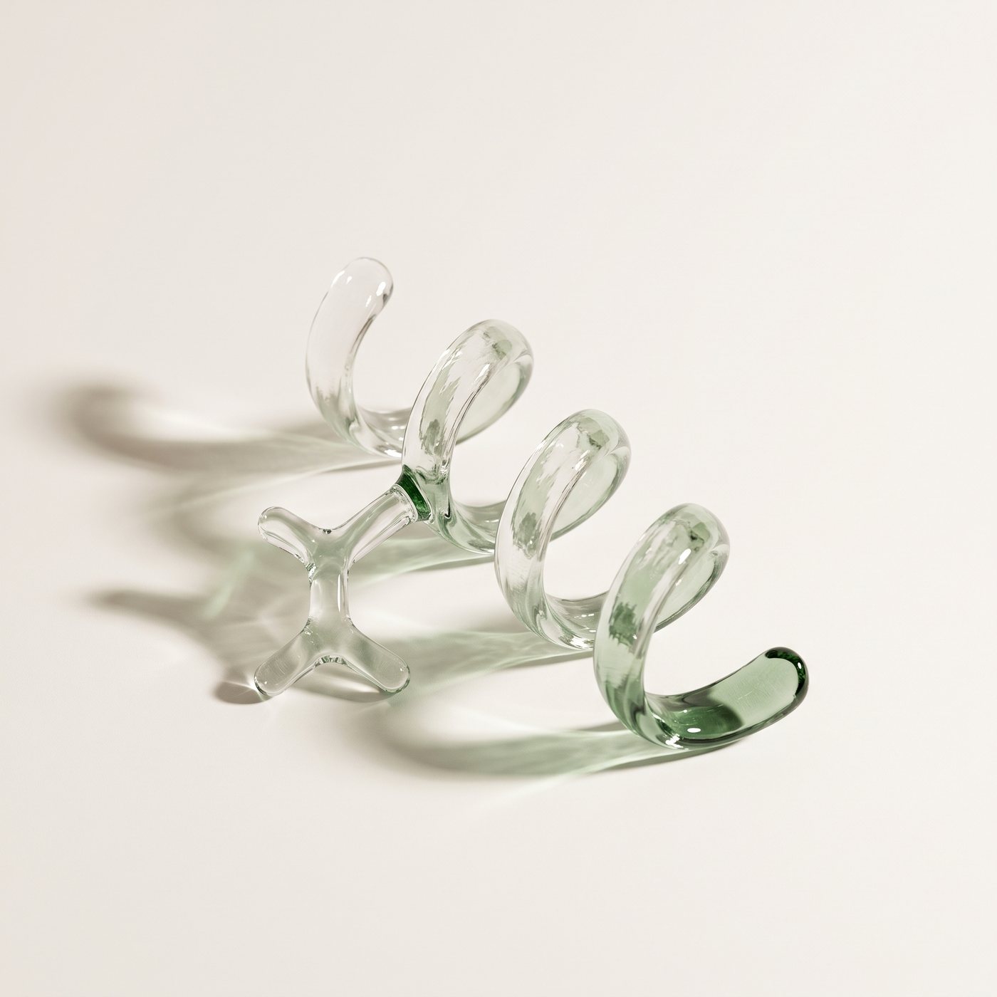 A glass sculpture of a peptide chain resting on an off-white surface